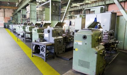 Factory line Row of green metal lathes in factory.